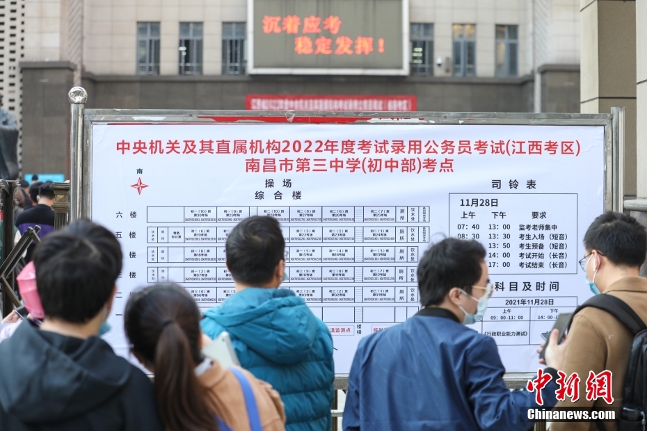 11月28日，江西南昌第三中学(初中部)考点，考生们在查看考场安排表。当日，中央机关及其直属机构2022年度考试录用公务员公共科目笔试举行。中新社记者 刘力鑫 摄