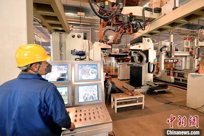 资料图：车间内工作人员进行机器操作。中新社记者 李佩珊 摄 